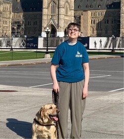 Jen and her guide dog Parmesan pose for a picture at Parliament in Ottawa.